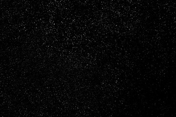 Falling snow on a black background. small particles with bright dots starry sky. Сhaotic white bokeh. light spots texture. abstract.