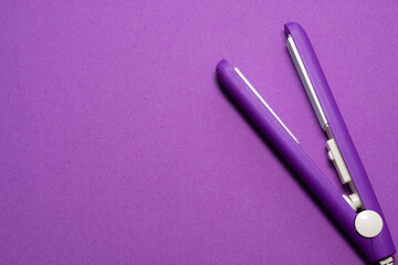 small size travel hair care tool on purple background. purple iron for hair 