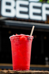 Refreshing cool lemonade with strawberries and ice in plastic glass