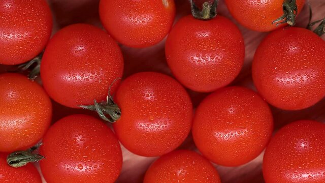 Top view of ripe red tomatoes. Tomatoes in slow motion on a round wooden moving platform