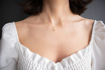 Close up detail of a beautiful necklace. Young perfect brunette woman with gold chain necklace....