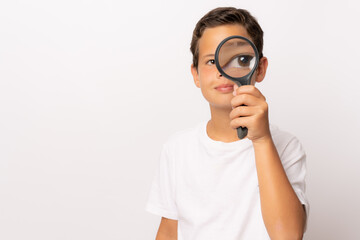 Boy using magnifier looking close up on white background