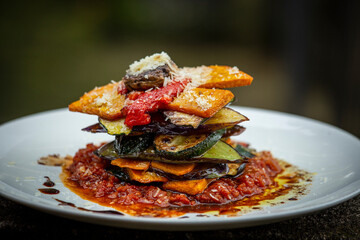 Vegetable stack - pumpkin, zucchini, red capsicum, eggplant and mushroom cooked in a tomato, onion, and garlic sauce topped with parmesan cheese