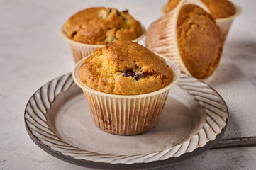 Macro cupcakes with cherries on plate on light background, selective focus