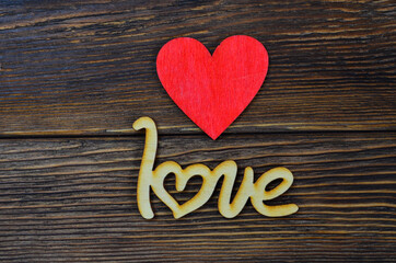 valentine's day background with wooden decor in the shape of a red heart and the inscription love flat lay