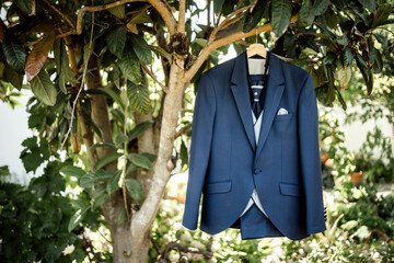 Elegant dark blue suit hanging on a tree