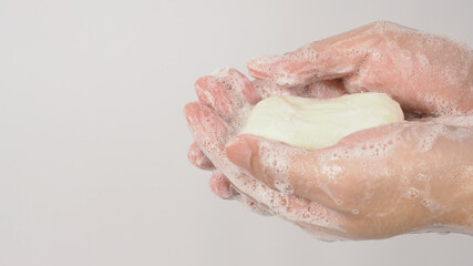 Fototapeta premium Hands washing gesture with bar soap and foam bubble on white background.