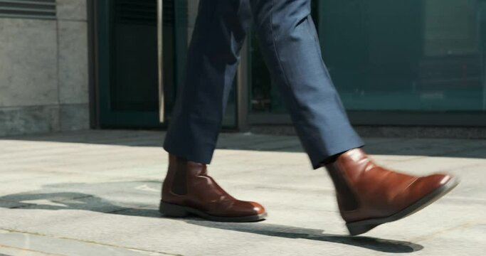 Low section of businessman walking outside office building