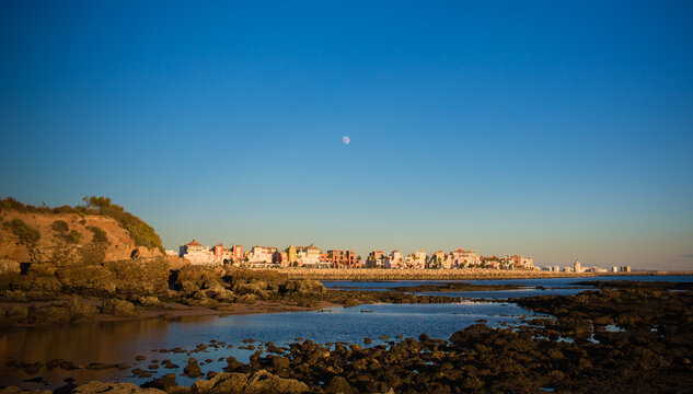 pueblo pesquero rodeado de agua de mar con un bonito cielo azul la luna y playas