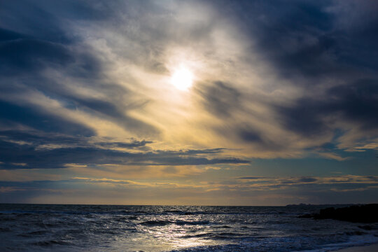 bonito atardecer en la playa con el mar y cielo azul con un sol amarillo