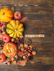 Ripe pumpkins, cones, nuts, apples on wooden table. November time. autumn season, harvesting. thanksgiving holiday concept. flat lay