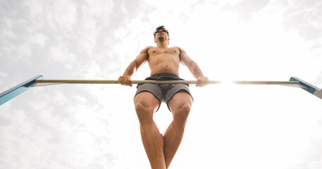 
a young athlete doing sports on top of a bar.
hard work.