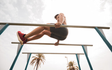 
a young athlete doing sports on top of a bar.
hard work.