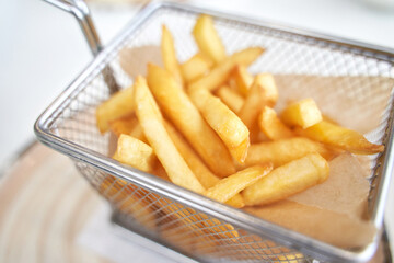 Basket with french fry. Potato chips. Cooking uhealthy lunch. Salty spicy junk. Oil takeaway gastronomy