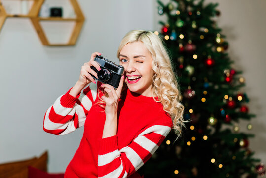 Female portrait with beautiful smile and curls on blond hair. Woman holds camera lady photographer.