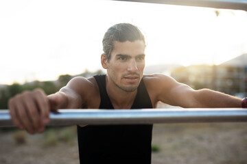 Naklejka premium Sporty athletic man exercises at the beach. Handsome man training outdoors