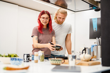 Young white couple cooking together in kitchen, at home