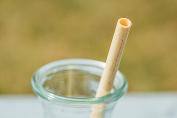 Glass jug with fully biodegradable and organic bamboo straw, close up