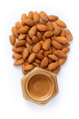 Almond butter smooth in glass jar on white background, urbech. Natural paste from almond nuts. Top view, close-up.