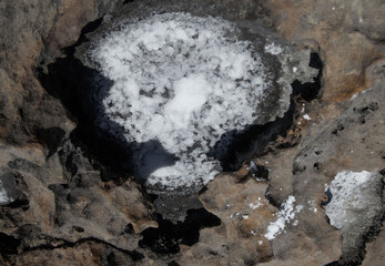 backgrounds and texture on the seashore in stone deposits flooded with water and the remains of sea salt frozen in time