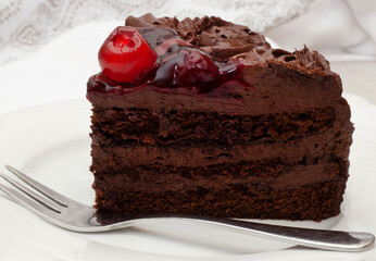 cherry on top of rich chocolate cake slice