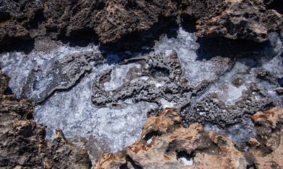 backgrounds and texture on the seashore in stone deposits flooded with water and the remains of sea salt frozen in time