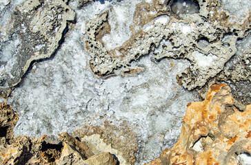 backgrounds and texture on the seashore in stone deposits flooded with water and the remains of sea salt frozen in time
