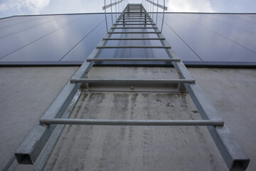 Fire escape on the industrial building above, bottom view. Stainless steel handrails, roof ladder....