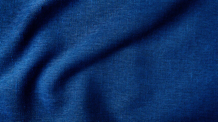 close up texture of creased fabric. blue woolen fabric. blue wavy cloth background showing fiber detail. blue fabric background with beautiful light and shadow.