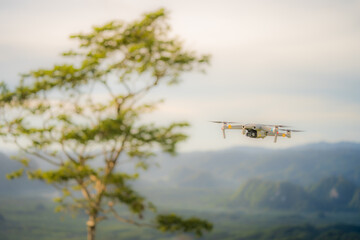 Flying drone above the view of mountains, trees and hills. Concept drone taking photo during travel