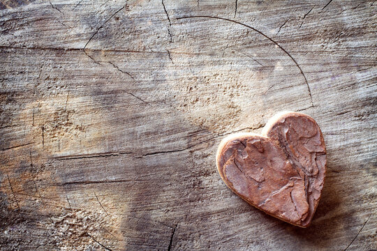 Carved wooden heart on old wood. Love background, free space