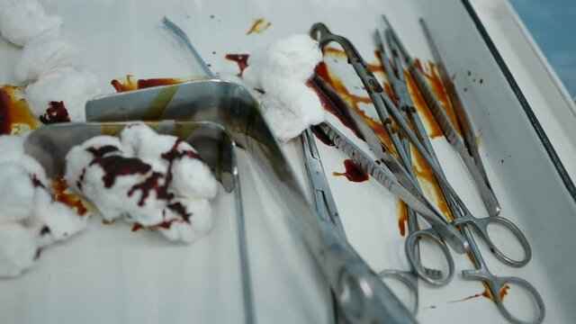 Dirty bloodstained medical utensils and tools on a gloomy table