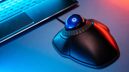 Trackball Computer Mouse on a blue background. Control Device with Scroll Wheel