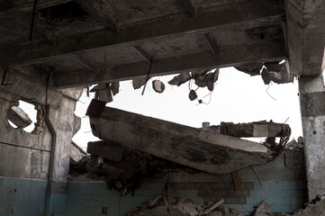 A ruined wall with a pile of debris against the gray sky. Background