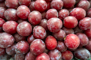 photo of a lot of plums on the counter of the store