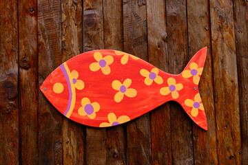 colourful painted fish model with wooden background.