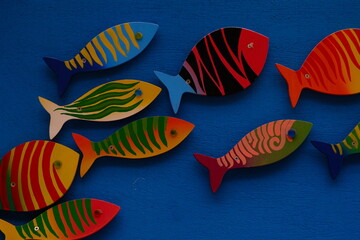 colorfully painted wooden fish models with blue background.