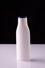 cosmetic cream in a white bottle, on a white table and black background