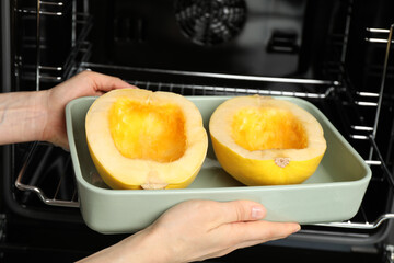 Woman putting halves of fresh spaghetti squash into oven, closeup