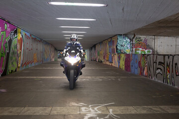 Motorradfahrer in bunten Graffiti Tunnel 