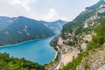 Landscape with big lake in mountains and road along.