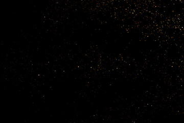 Golden abstract bokeh on black background.