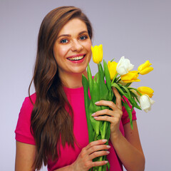 smiling girl in red dress holding yellow and white tulips.