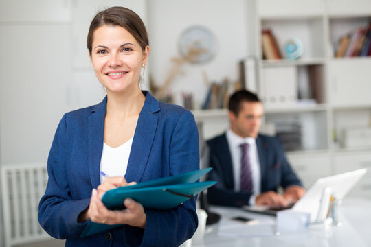 Portrait of positive business woman with folder of documents at office