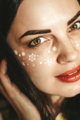 girl with New Year's makeup. snowflakes on the cheeks of a girl