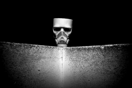 M&aacute;scara blanco sobre muro con fondo negro.