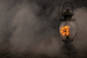 Vintage lamps glow on top of smoke against the black background.