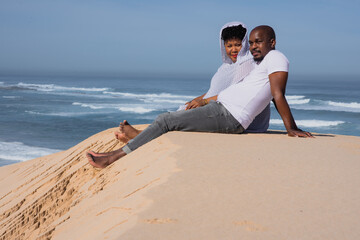 Couple seen relaxing on sand dune 