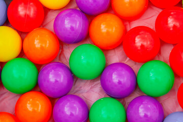 Fototapeta na wymiar Piscina de bolas de plástico de colores (fondo de colores). Bolas apiladas para jugar en un parque infantil.