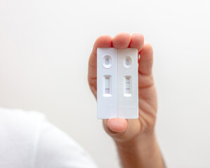 Man hand holding Covid 19 positive and negative result self test.